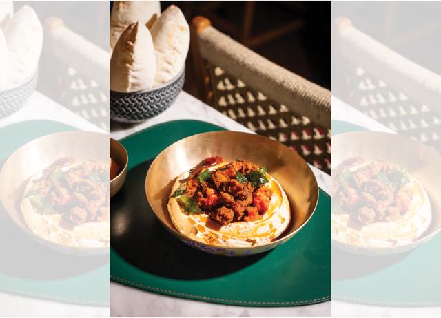 Mezze Mambo’s podi chicken hummus is topped with mustard seeds, fried red chili and curry leaves.