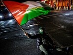 A Pro-Palestinian protester sits on the street as others march to stand with Palestinians in Gaza following the announcement of the ceasefire
