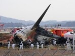 Rescue team members work at the site of a plane crash at Muan International Airport in South Korea.
