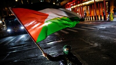 A Pro-Palestinian protester sits on the street as others march to stand with Palestinians in Gaza following the announcement of the ceasefire (REUTERS/Eduardo Munoz)