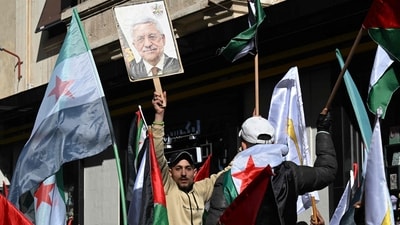 A man lifts a picture of Mahmoud Abbas as people take to the streets of Damascus to show their support for the Palestinian Authority in front of the Palestinian embassy in Damascus on January 9, 2025. (AFP) A man lifts a picture of Mahmoud Abbas as people take to the streets of Damascus to show their support for the Palestinian Authority in front of the Palestinian embassy in Damascus on January 9, 2025. (AFP)