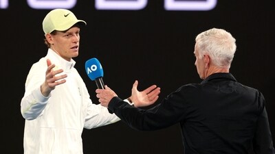 Italy's Jannik Sinner (L) talks with former tennis player John McEnroe after a match. (AFP)
