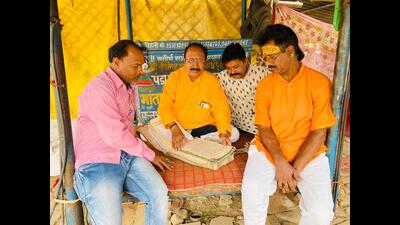 Teerth Purohit Rajendra Paliwal at his camp, making entries for pilgrims arriving for Kalpwas in Sector 6 of Mahakumbh Nagar on Sunday. (HT ) Teerth Purohit Rajendra Paliwal at his camp, making entries for pilgrims arriving for Kalpwas in Sector 6 of Mahakumbh Nagar on Sunday. (HT )