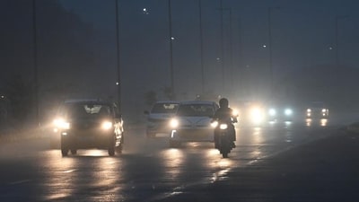 Traffic moves amid rain and morning fog in Delhi's Dwarka. (Vipin Kumar/HT Photo)
