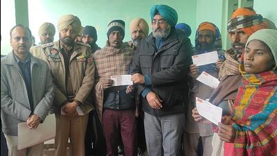 Bathinda SDM Balkaran Singh Mahal hands over the cheques to victims at Daan Singh Wala village on Saturday. (HT Photo)
