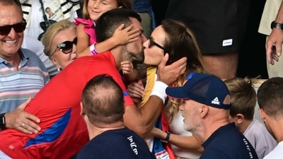 Novak Djokovic gives his wife Jelena a kiss as he celebrates with his family in the crowd after beating Spain's Carlos Alcaraz in their Paris 2024 men's singles final. (AFP)
