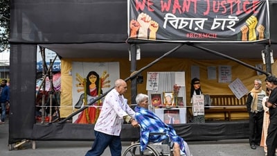 A man pushes a wheelchair-bound patient in front of posters and installations displayed to condemn the rape and murder of a doctor at the protest site inside the state-run RG Kar Medical College and Hospital in Kolkata on the eve of the court's verdict. (AFP) A man pushes a wheelchair-bound patient in front of posters and installations displayed to condemn the rape and murder of a doctor at the protest site inside the state-run RG Kar Medical College and Hospital in Kolkata on the eve of the court's verdict. (AFP)