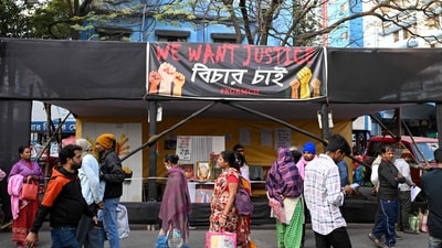 People walk past posters and installations displayed to condemn the rape and murder of a doctor at the protest site inside the state-run RG Kar Medical College and Hospital in Kolkata on January 17, 2025, on the eve of the court's verdict. (AFP)