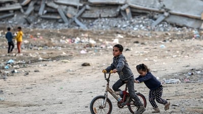 The war broke out after Hamas on October 7, 2023, launched an attack on Israel, killing 1,200 people and taking around 250 hostages, In pic: A girl pushes a boy riding a bicycle near the rubble of a collapsed building at a camp for people displaced by conflict in Bureij in the central Gaza Strip on January 17, 2025 following the announcement of a truce amid the ongoing war between Israel and Hamas. (AFP) The war broke out after Hamas on October 7, 2023, launched an attack on Israel, killing 1,200 people and taking around 250 hostages, In pic: A girl pushes a boy riding a bicycle near the rubble of a collapsed building at a camp for people displaced by conflict in Bureij in the central Gaza Strip on January 17, 2025 following the announcement of a truce amid the ongoing war between Israel and Hamas. (AFP)