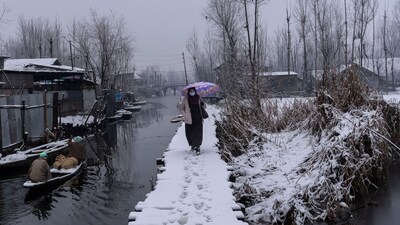 A Kashmiri walks on a snow-covered footbridge as boatmen row past her in the interiors of Dal Lake in Srinagar, Indian controlled Kashmir, Jan. 6, 2025. (AP/Representative) A Kashmiri walks on a snow-covered footbridge as boatmen row past her in the interiors of Dal Lake in Srinagar, Indian controlled Kashmir, Jan. 6, 2025. (AP/Representative)