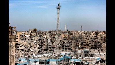 A man fixes a Palestinian flag atop the antenna of a destroyed building that was a clinic for the United Nations Relief and Works Agency for Palestine Refugees (UNRWA) at the Jabalia camp for Palestinian refugees in the northern Gaza Strip on January 19, 2025. (Photo by Omar AL-QATTAA / AFP) (AFP) A man fixes a Palestinian flag atop the antenna of a destroyed building that was a clinic for the United Nations Relief and Works Agency for Palestine Refugees (UNRWA) at the Jabalia camp for Palestinian refugees in the northern Gaza Strip on January 19, 2025. (Photo by Omar AL-QATTAA / AFP) (AFP)