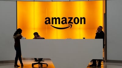 In this photo, people stand in the lobby for Amazon offices in New York (Mark Lennihan/AP)