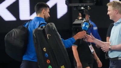 Novak Djokovic of Serbia hands a microphone to Jim Courier after his match against Jiri Lehecka of the Czech Republic during their fourth round match at the Australian Open tennis championship in Melbourne (AP) Novak Djokovic of Serbia hands a microphone to Jim Courier after his match against Jiri Lehecka of the Czech Republic during their fourth round match at the Australian Open tennis championship in Melbourne (AP)