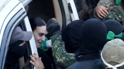 Thousands of Israelis celebrated, hugged, or sobbed in a plaza when the three female captives emerged from a car flanked by armed Hamas members on a huge screen outside the defence headquarters in Tel Aviv. (REUTERS/Dawoud Abu Alkas)