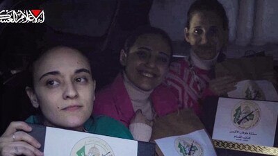 This image grab from a handout video released by the Hamas Media Office shows Israeli hostages (L to R) Emily Damari, Romi Gonen, and Doron Steinbracher, who were abducted by Palestinian militants during the October 7, 2023 attacks, posing with documents bearing the logo of the Ezzedine al-Qassam Brigades, Hamas's armed wing, certifying the ceasefire and hostage-prisoner exchange deal in the war between Israel and Hamas, as they sit in a Hamas vehicle before being handed over to the International Committee of the Red Cross (ICRC) in the Gaza Strip on January 19, 2025. (Photo by HAMAS MEDIA OFFICE / AFP) (AFP) This image grab from a handout video released by the Hamas Media Office shows Israeli hostages (L to R) Emily Damari, Romi Gonen, and Doron Steinbracher, who were abducted by Palestinian militants during the October 7, 2023 attacks, posing with documents bearing the logo of the Ezzedine al-Qassam Brigades, Hamas's armed wing, certifying the ceasefire and hostage-prisoner exchange deal in the war between Israel and Hamas, as they sit in a Hamas vehicle before being handed over to the International Committee of the Red Cross (ICRC) in the Gaza Strip on January 19, 2025. (Photo by HAMAS MEDIA OFFICE / AFP) (AFP)