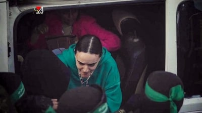 The three ladies were reunited with their families in Israel after being encircled by thousands of people, including armed Hamas members wearing masks. (AFP) The three ladies were reunited with their families in Israel after being encircled by thousands of people, including armed Hamas members wearing masks. (AFP)