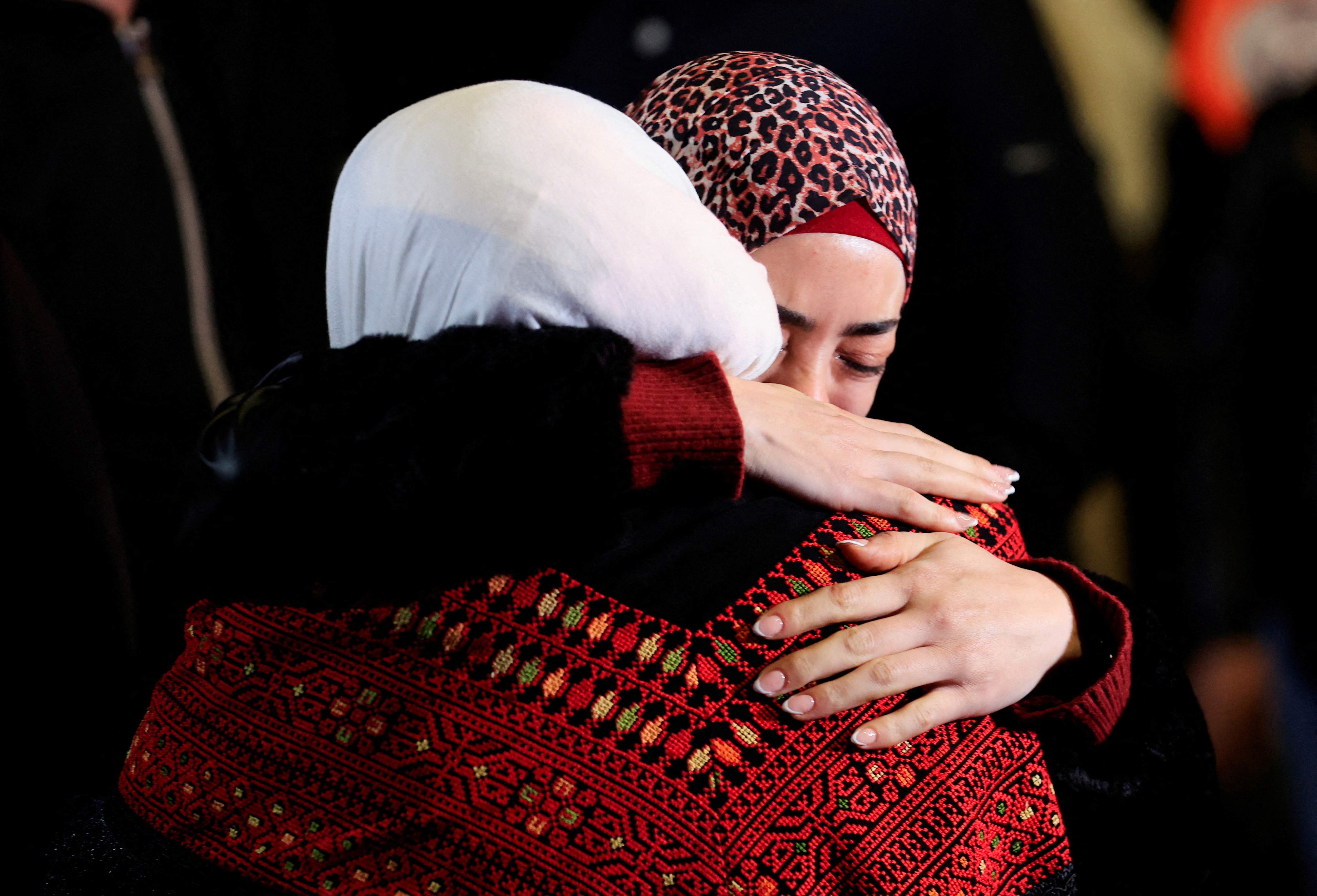 Palestinians embrace emotions buses carrying freed Palestinians prisoners from Israel arrive in the Israeli-occupied West Bank.  (Reuters)
