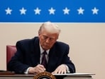 US President Donald Trump signs an executive order during the 60th presidential inauguration parade at Capital One Arena in Washington, DC, US, on Monday. (Bloomberg)