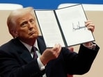 President Donald Trump holds up an executive order after signing it at an indoor Presidential Inauguration parade event in Washington, Monday. President Donald Trump holds up an executive order after signing it at an indoor Presidential Inauguration parade event in Washington, Monday.