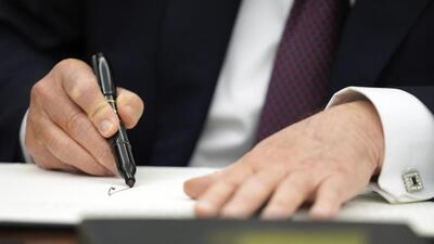 President Donald Trump signs executive orders in the Oval Office of the White House on Monday. (AP) President Donald Trump signs executive orders in the Oval Office of the White House on Monday. (AP)