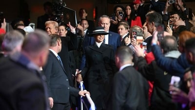 US President Donald Trump (L) and First Lady Melania Trump arrive at the inaugural parade inside Capital One Arena in Washington DC. First lady Melania wore an all-American ensemble for Monday’s inaugural ceremony, choosing a navy and ivory ensemble by Adam Lippes and a coordinating hat by Eric Javits. (AFP) US President Donald Trump (L) and First Lady Melania Trump arrive at the inaugural parade inside Capital One Arena in Washington DC. First lady Melania wore an all-American ensemble for Monday’s inaugural ceremony, choosing a navy and ivory ensemble by Adam Lippes and a coordinating hat by Eric Javits. (AFP)