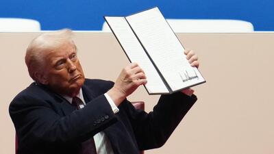 US President Donald Trump holds up an executive order. (Getty Images via AFP) US President Donald Trump holds up an executive order. (Getty Images via AFP)