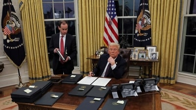 US President Donald Trump signs documents as he issues executive orders and pardons for January 6 defendants in the Oval Office at the White House on Inauguration Day in Washington. (REUTERS)