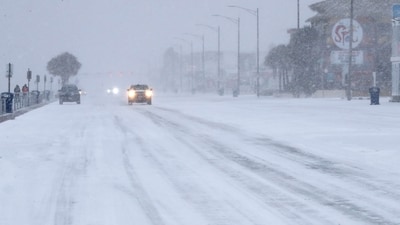 Drivers slowly make their way along Seawall Boulevard in Galveston, Texas during a snowstorm Tuesday. (AP) Drivers slowly make their way along Seawall Boulevard in Galveston, Texas during a snowstorm Tuesday. (AP)