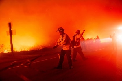 A firefighter pulls a hose while trying to keep the Lilac Fire from spreading near the Bonsall community of San Diego County, Calif., on Tuesday, Jan. 21, 2025. (AP Photo/Noah Berger) (AP) A firefighter pulls a hose while trying to keep the Lilac Fire from spreading near the Bonsall community of San Diego County, Calif., on Tuesday, Jan. 21, 2025. (AP Photo/Noah Berger) (AP)