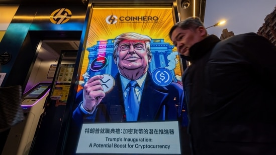 A cartoon image of US President-elect Donald Trump with cryptocurrency tokens, depicted in front of the White House to mark his inauguration, displayed at a Coinhero store in Hong Kong, China, on Monday, Jan. 20, 2025. Bitcoin reached an all-time high as the US prepares to inaugurate pro-crypto President-elect Donald Trump.(Paul Yeung/Bloomberg)