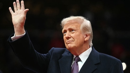 US President Donald Trump waves as he arrives at the inaugural parade inside Capitol One Arena in Washington, DC. (AFP)