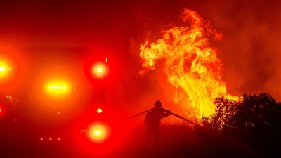 A firefighter sprays water while battling the Lilac Fire near the Bonsall community of San Diego County in California on January 21. Evacuation orders were issued for the Lilac Fire, which had burned about 50 acres (20 hectares). (AP) A firefighter sprays water while battling the Lilac Fire near the Bonsall community of San Diego County in California on January 21. Evacuation orders were issued for the Lilac Fire, which had burned about 50 acres (20 hectares). (AP)