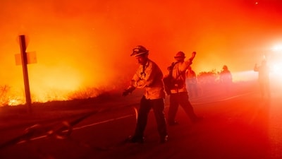 A firefighter pulls a hose while trying to keep the Lilac Fire from spreading near the Bonsall community of San Diego County, Calif., on Tuesday, Jan. 21, 2025. (AP Photo/Noah Berger) (AP) A firefighter pulls a hose while trying to keep the Lilac Fire from spreading near the Bonsall community of San Diego County, Calif., on Tuesday, Jan. 21, 2025. (AP Photo/Noah Berger) (AP)