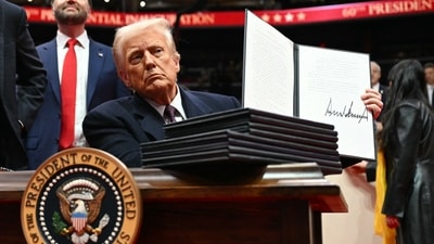 US President Donald Trump holds an executive order he just signed during the inaugural parade inside Capital One Arena, in Washington, DC. (AFP) US President Donald Trump holds an executive order he just signed during the inaugural parade inside Capital One Arena, in Washington, DC. (AFP)