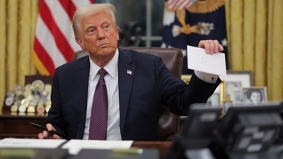 U.S. President Donald Trump holds former United States President Joe Biden's letter on the day he signs documents as he issues executive orders and pardons for January 6 defendants in the Oval Office at the White House on Inauguration Day in Washington, U.S., January 20, 2025.  REUTERS/Carlos Barria (REUTERS)