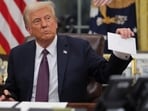 U.S. President Donald Trump holds former United States President Joe Biden's letter on the day he signs documents as he issues executive orders and pardons for January 6 defendants in the Oval Office at the White House on Inauguration Day in Washington, U.S., January 20, 2025.  REUTERS/Carlos Barria