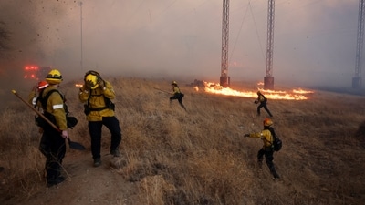 Firefighters take cover as a tornado hits while the Hughes Fire burns in Castaic Lake, California, U.S. January 22, 2025. REUTERS/David Swanson (REUTERS)
