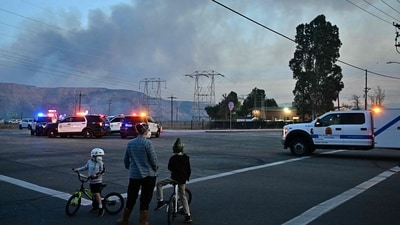 People watch the plume of smoke from the Hughes Fire in Castaic, a neighborhood in northwest Los Angeles County, California. Interstate 5 will soon restore some of its blocked sections. (AFP/Frederic J. Brown) People watch the plume of smoke from the Hughes Fire in Castaic, a neighborhood in northwest Los Angeles County, California. Interstate 5 will soon restore some of its blocked sections. (AFP/Frederic J. Brown)