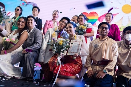 A same-sex couple (C) poses for pictures at a marriage registration event at Paragon shopping mall in Bangkok A same-sex couple (C) poses for pictures at a marriage registration event at Paragon shopping mall in Bangkok