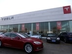 A Tesla car is driven past a store of the electric vehicle (EV) maker in Beijing, China January 4, 2024.