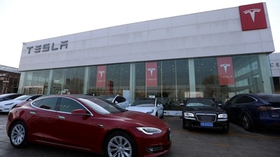 A Tesla car is driven past a store of the electric vehicle (EV) maker in Beijing, China January 4, 2024. (Florence Lo/Reuters)