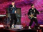 Musician Chris Martin (L) of the British rock band Coldplay, performs onstage during a concert as part of their Music of the Spheres World Tour, at the D.Y. Patil stadium in Navi Mumbai on January 18, 2025. (Photo by SUJIT JAISWAL / AFP) / ----IMAGE RESTRICTED TO EDITORIAL USE - STRICTLY NO COMMERCIAL USE-----