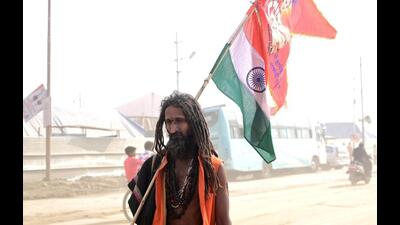 A sadhu walking in Mahakumbh Nagar carrying a religious flag and the Tricolour together. (HT photo) A sadhu walking in Mahakumbh Nagar carrying a religious flag and the Tricolour together. (HT photo)