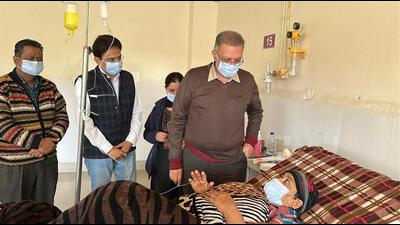 Health minister Dr Balbir Singh meeting the patient whose surgery was halted due to power outage. (HT Photo)