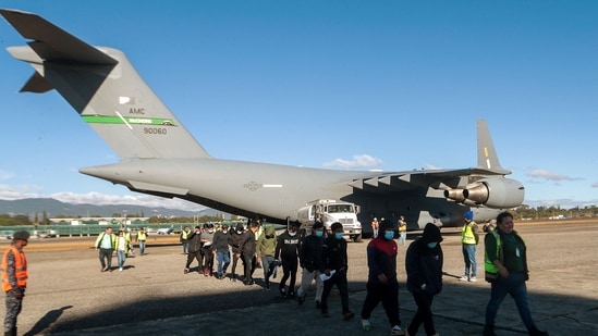A handout picture released by Guatemalan Migration Institute shows Guatemalan migrants descending from a US military plane after being deported from the US at the Guatemalan Air Force Base in Guatemala City on January 24, 2025. (AFP)