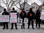Activists with Revcom Corps Chicago hold signs outside of Hamline Elementary School after federal agents were turned away in Chicago. 