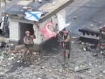 A drone view shows Russian service members waving flags on the roof of a building in the course of Russia-Ukraine conflict in the settlement of Velyka Novosilka in the Donetsk region, a Russian-controlled part of Ukraine, in this still image from video released January 26, 2025. 