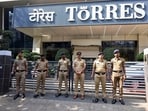 Police personnel stand guard outside Torres Company’s office.
