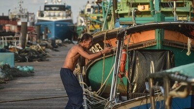 A fishman repairs a boat at Pulau Duyong Jetty in Kuala Terengganu on December 26, 2024. (Photo by ARIF KARTONO / AFP) (AFP) A fishman repairs a boat at Pulau Duyong Jetty in Kuala Terengganu on December 26, 2024. (Photo by ARIF KARTONO / AFP) (AFP)
