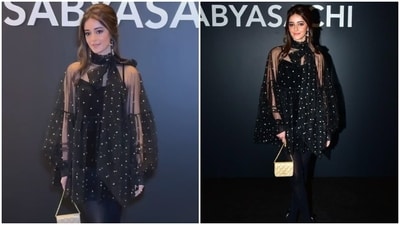 Ananya Panday added the yesteryear charm to Sabyasachi's runway show in a polka dot-printed sheer mini dress worn over a spaghetti-strap black velvet dress and sheer stockings. She accessorised the ensemble with a mini bag, statement earrings, a retro Hollywood half-up hairdo, black pumps, and minimal glam. Ananya Panday added the yesteryear charm to Sabyasachi's runway show in a polka dot-printed sheer mini dress worn over a spaghetti-strap black velvet dress and sheer stockings. She accessorised the ensemble with a mini bag, statement earrings, a retro Hollywood half-up hairdo, black pumps, and minimal glam. 